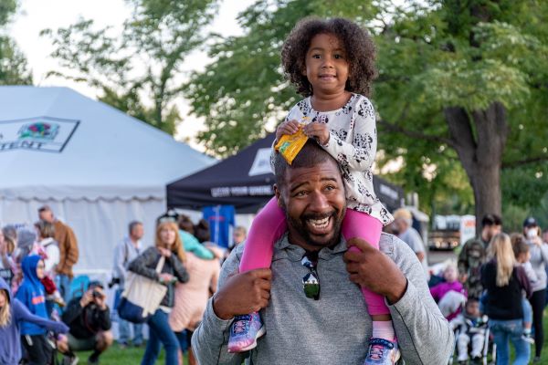 Daddy carrying a daughter on his shoulders at a carnival in the Bible say about Stewardship article.